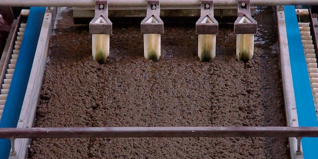 Dewatering process in a wastewater treatment plant, with thick sludge being processed on a centrifuge.