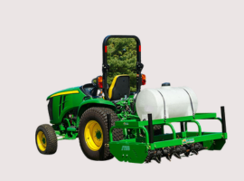 Green agricultural tractor with a rear-mounted aerator and tank, viewed from the back on a neutral background.