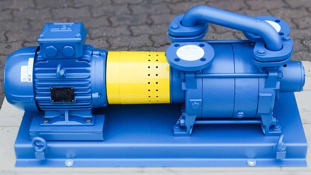 A blue industrial pump, tailored for efficient vacuum solutions in industrial applications, with a yellow coupling and mounted on a base. It boasts a finned motor for cooling and several bolted connections, ideal for liquid ring pumps on paved surfaces.